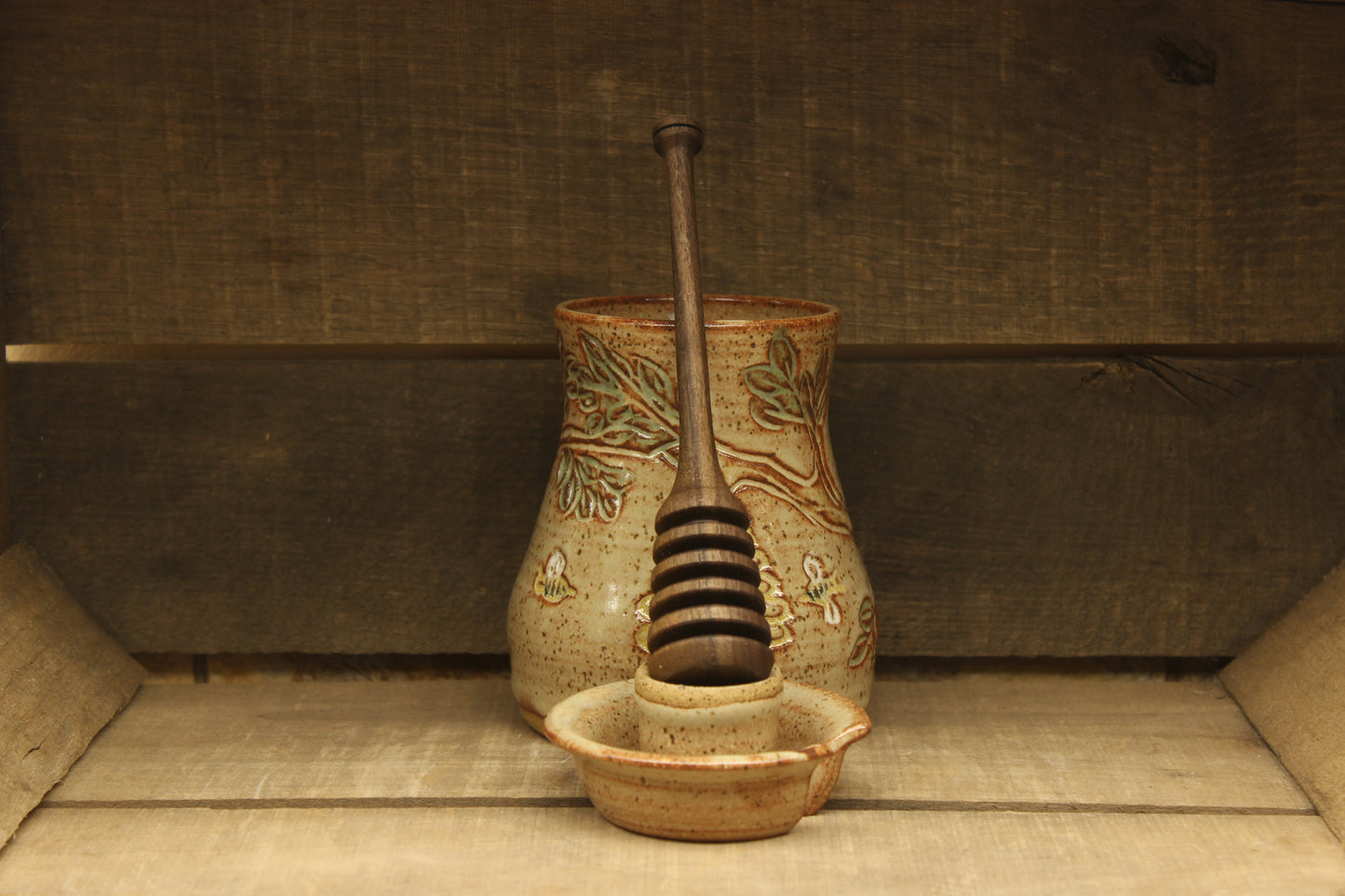 Ceramic honey pot with beehive and bees with a wood honey dipper