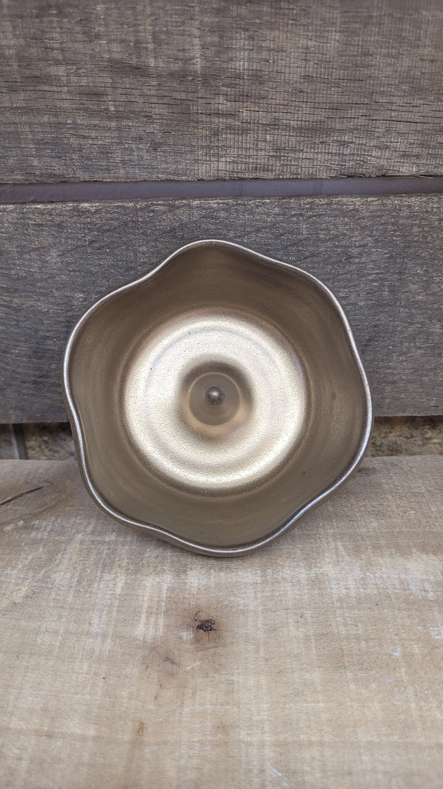 Gold ring dish on wood surface