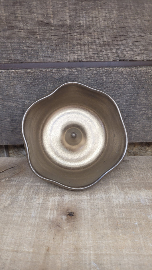 Gold ring dish on wood surface