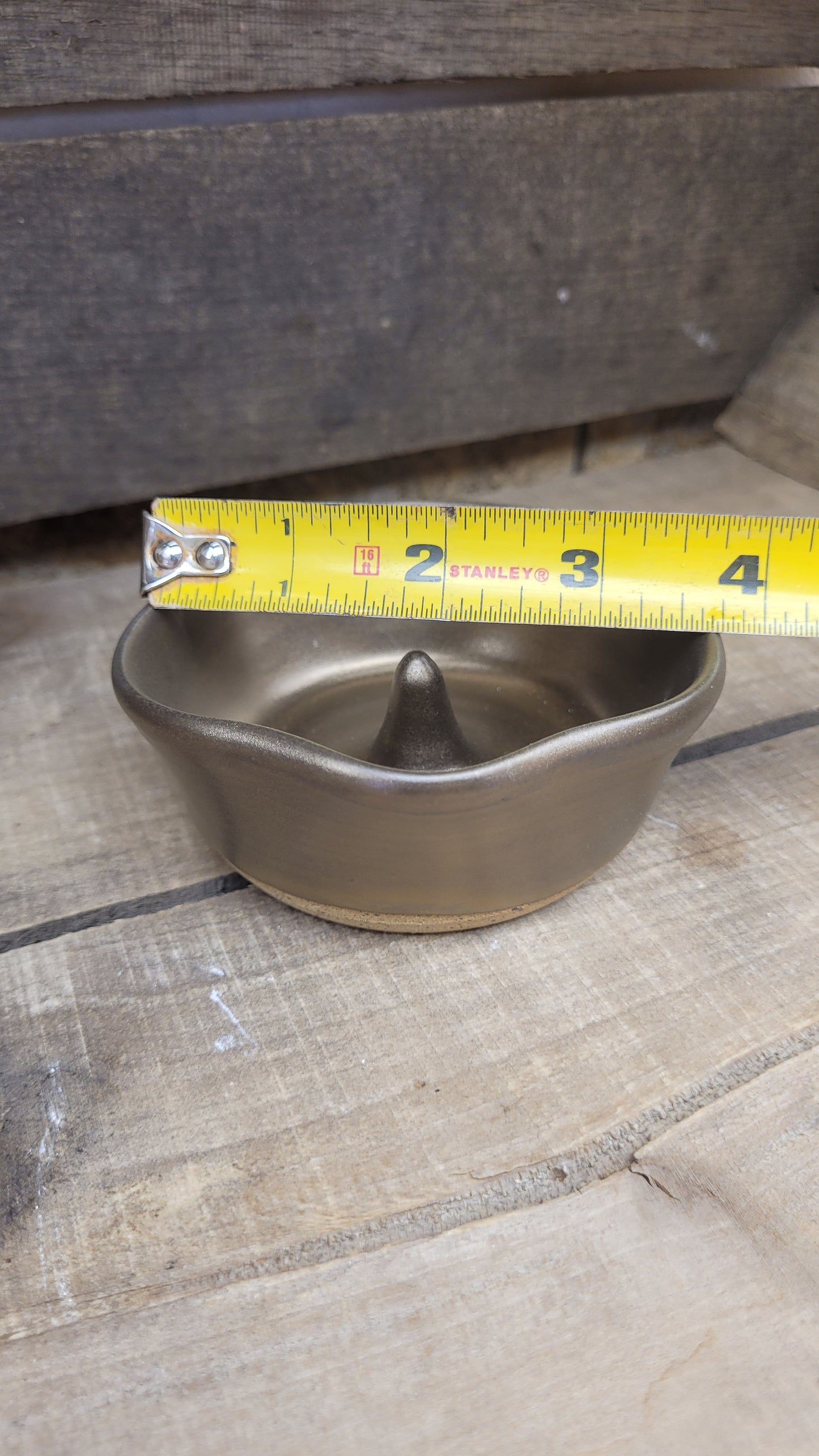 Gold ring dish on wood surface with tape measure
