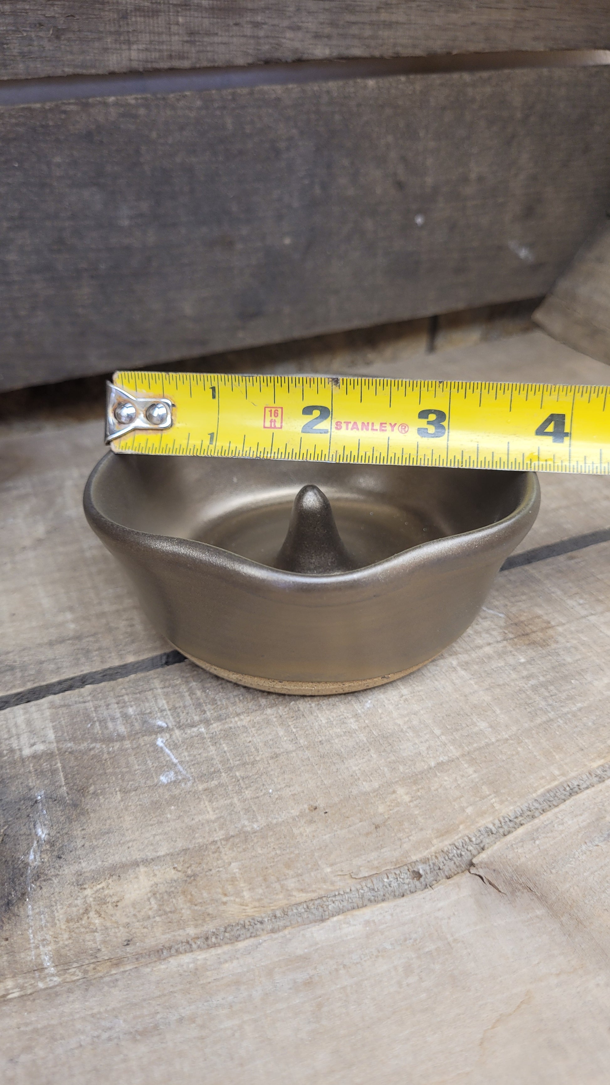 Gold ring dish on wood surface with tape measure